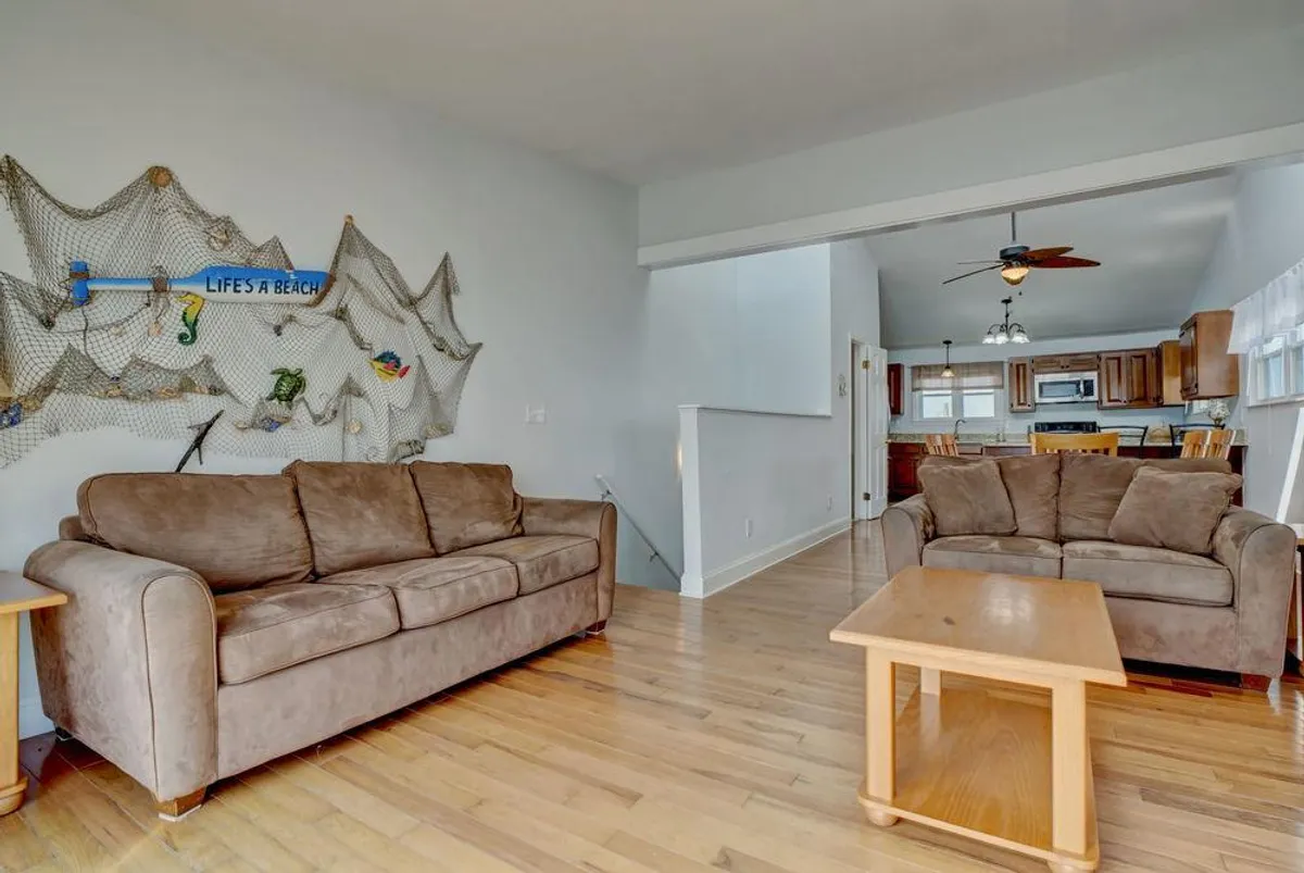 A comfortable living area featuring plush sofas, a central coffee table, and decorative wall art. The setup is perfect for relaxing, entertaining, or hosting group games and movie nights.